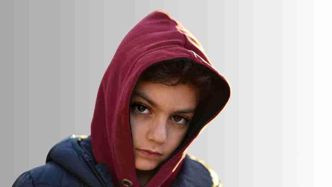 An unhappy boy wearing a hoody