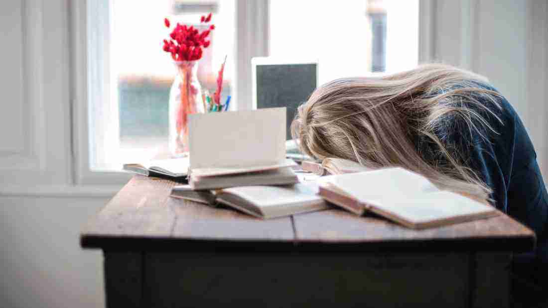 An exhausted woman sleeping on her desk