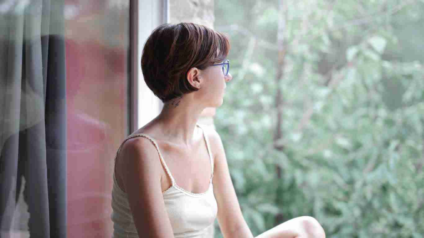 A woman gazing out of a window enjoying nature