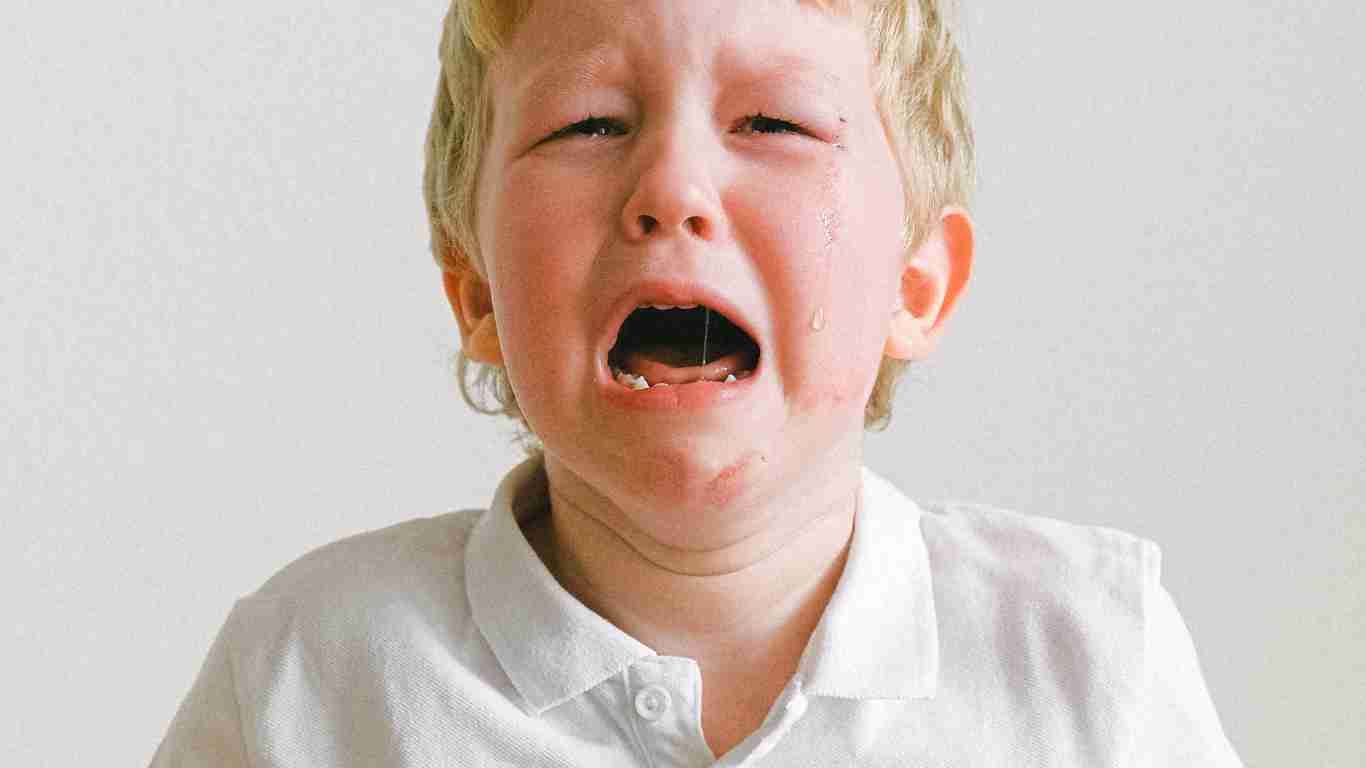 A distraught little boy with tears streaming down his face
