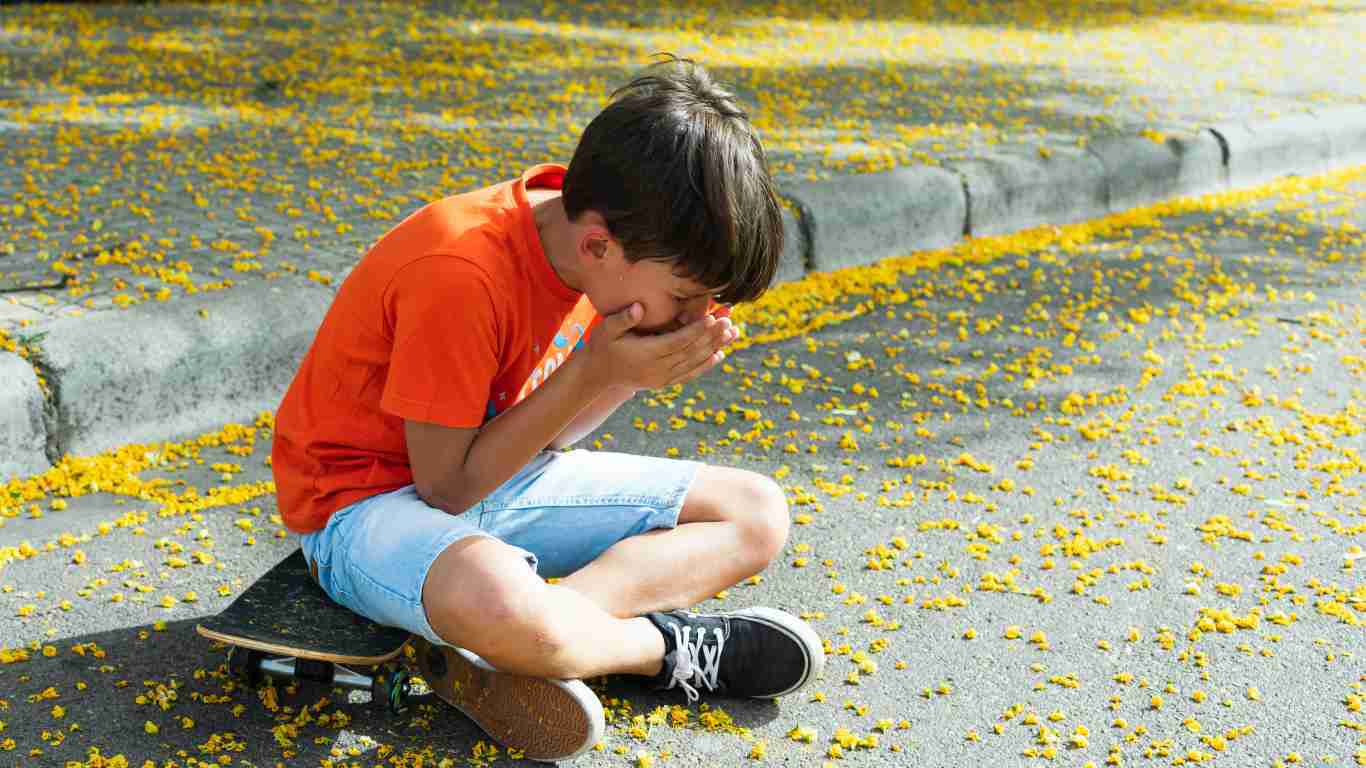Little boy hunched over and crying