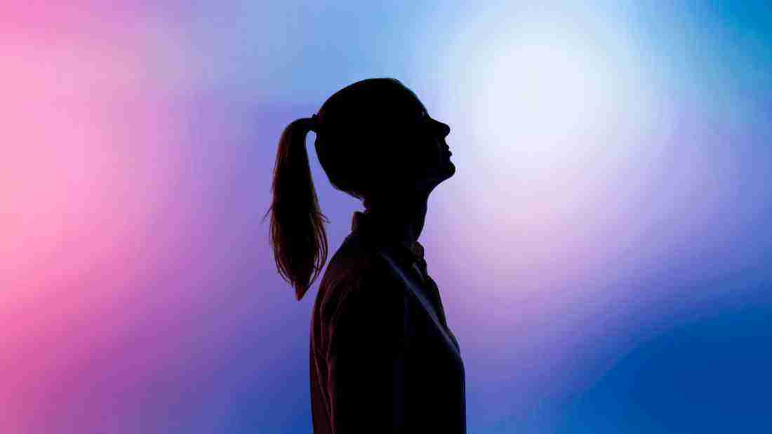 A woman standing in darkness
