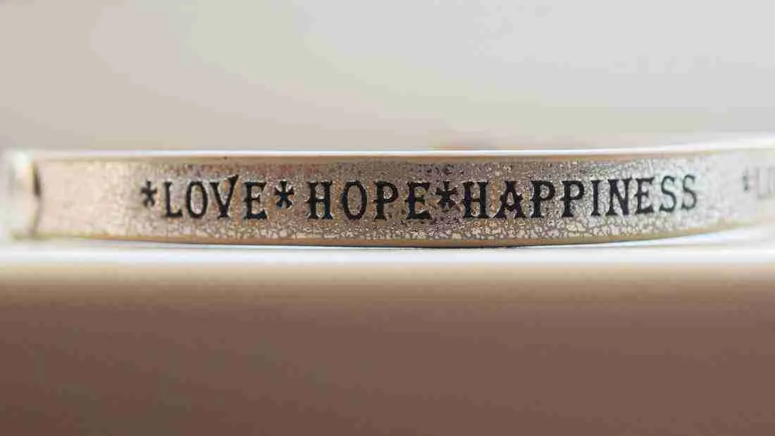 A friendship bracelet with the words Love, hope and happiness