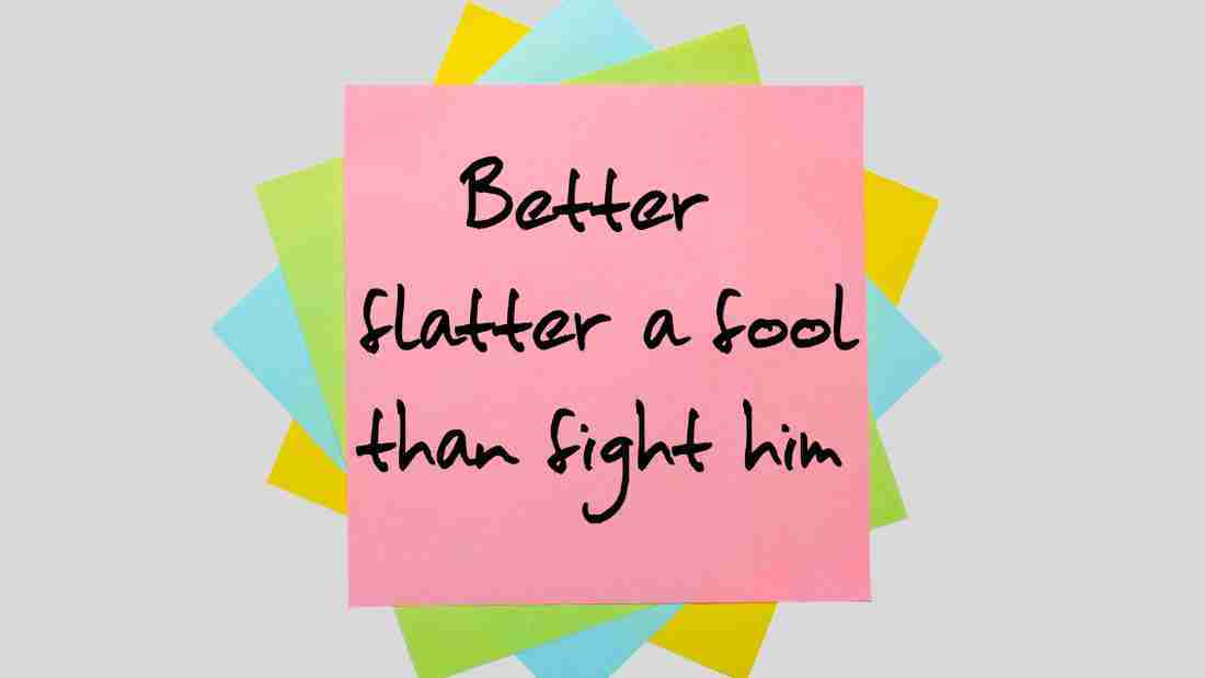 A post-it with the words BETTER FLATTER A FOOL THAN FIGHT HIM