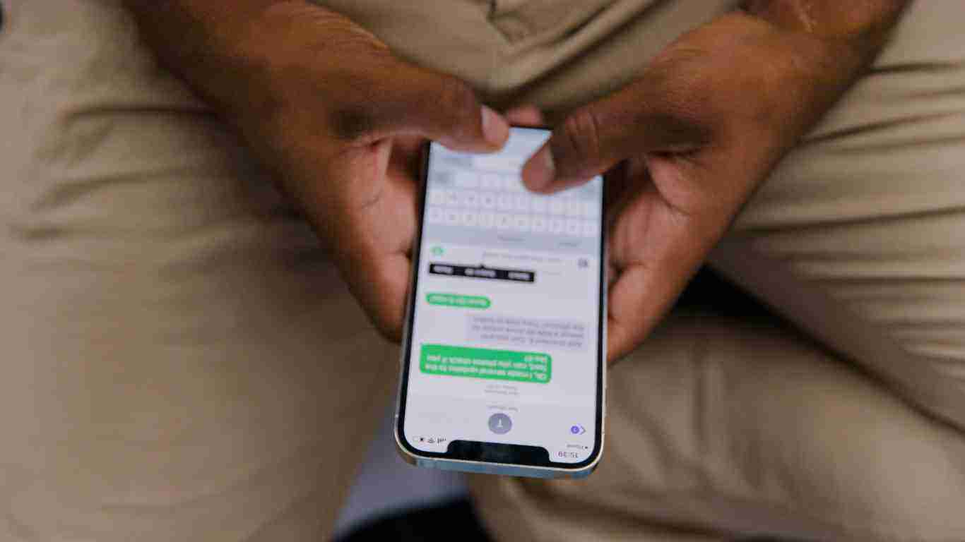 A black man sending a text message.