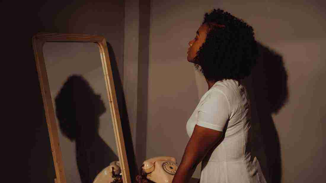 A woman staring at her reception in the mirror