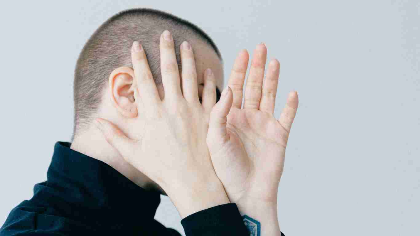 A shy woman covering her face
