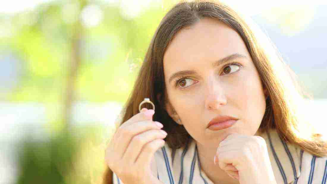 Woman taking off her engagement ring