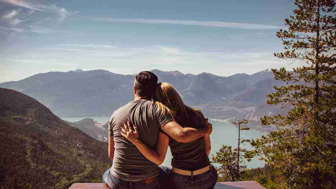 A couple embracing on top of a mountain