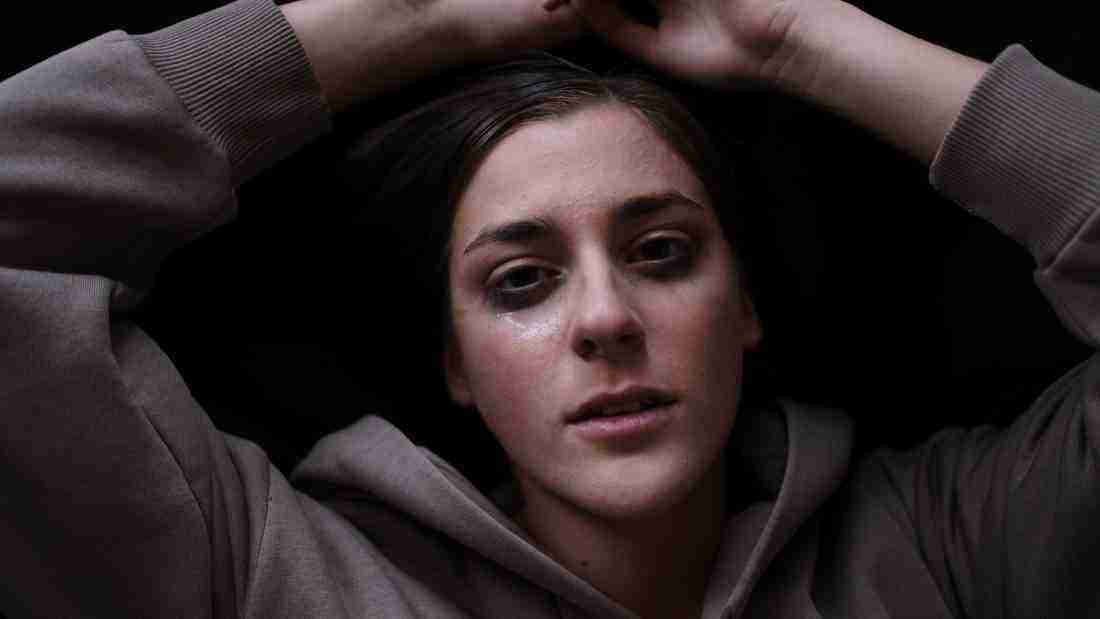 A depressed young woman crying in the dark