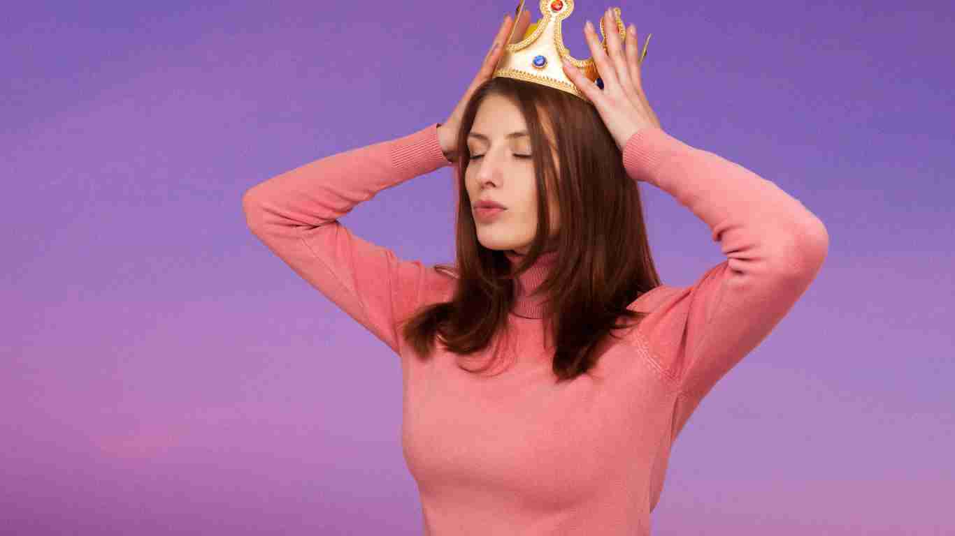 A narcissistic woman putting on a golden crown
