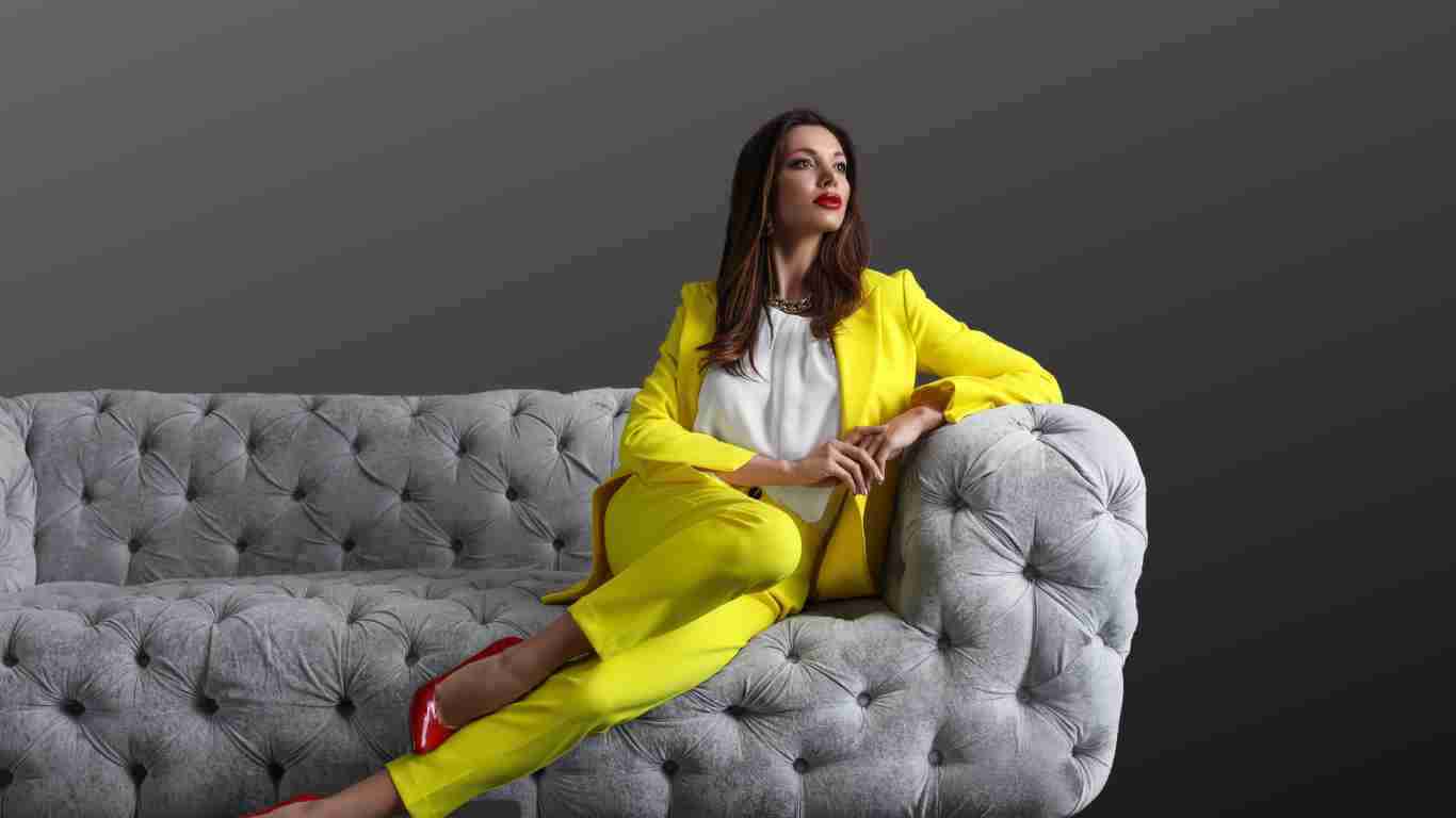 An arrogant woman striking a pose on a grey sofa
