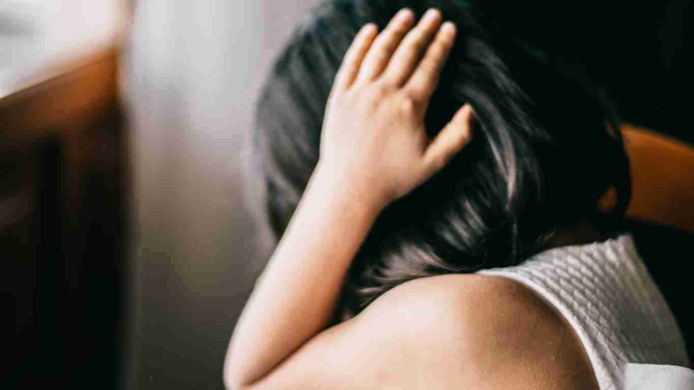 A terrified little girl covering her ears with her hands