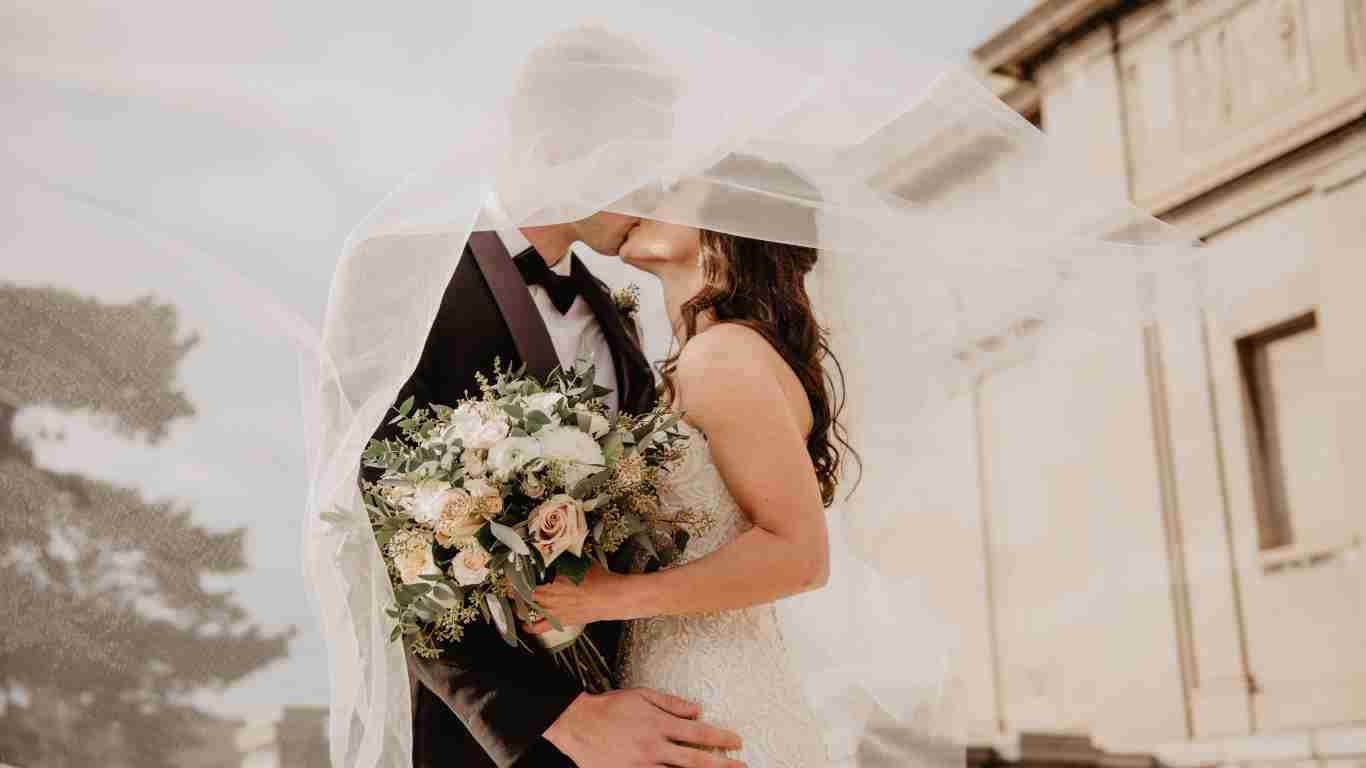 The bride and groom kissing after tying the know