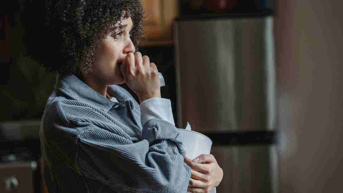 A woman crying as she stares out of the window