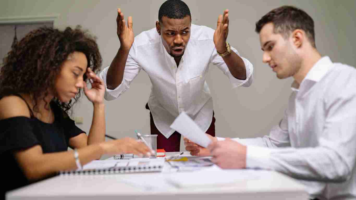 A man shouting at his colleagues during a business meeting