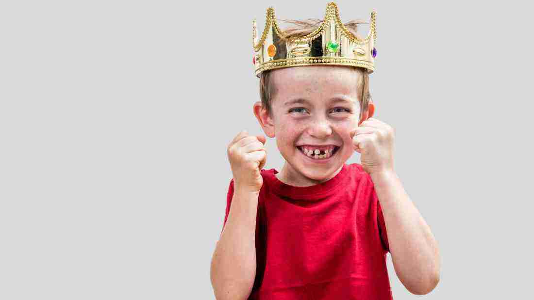Cheeky boy wearing a golden crown