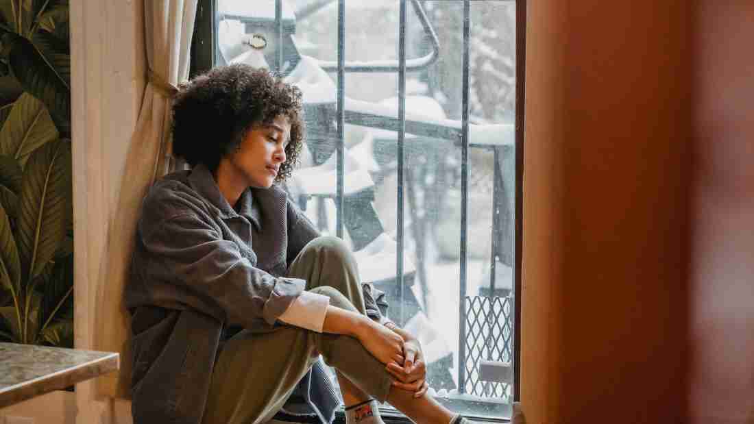 A depressed young woman gazing out of a window