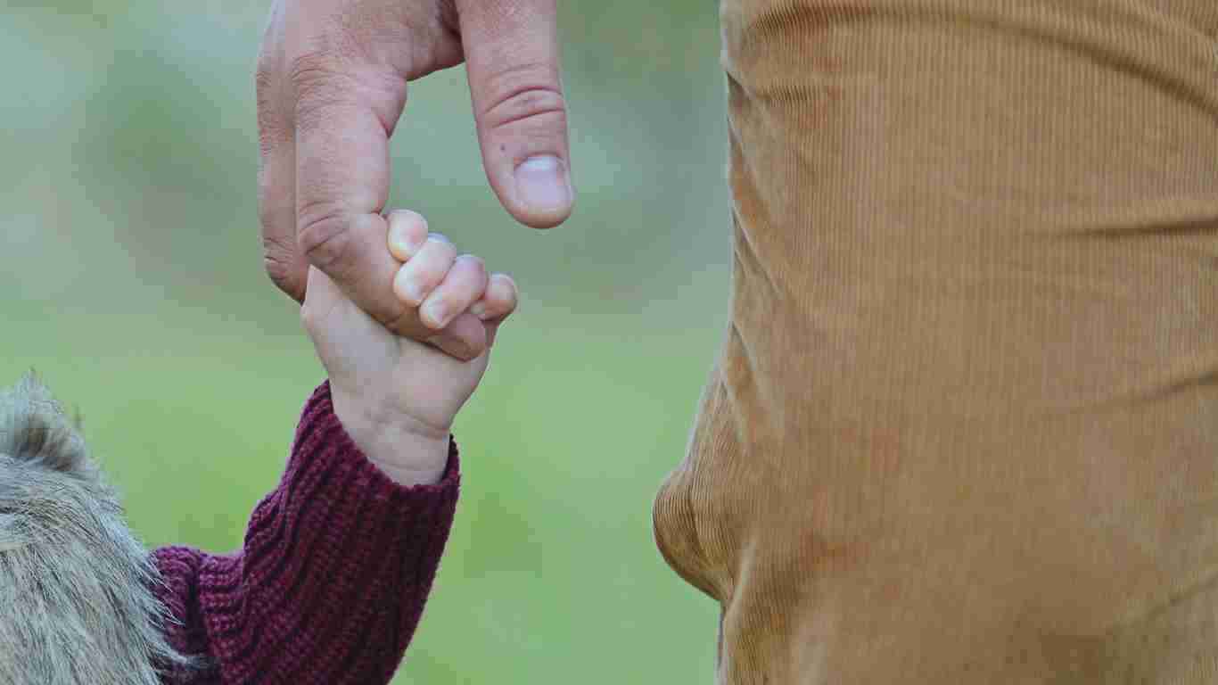 A father holding his daughter's hand