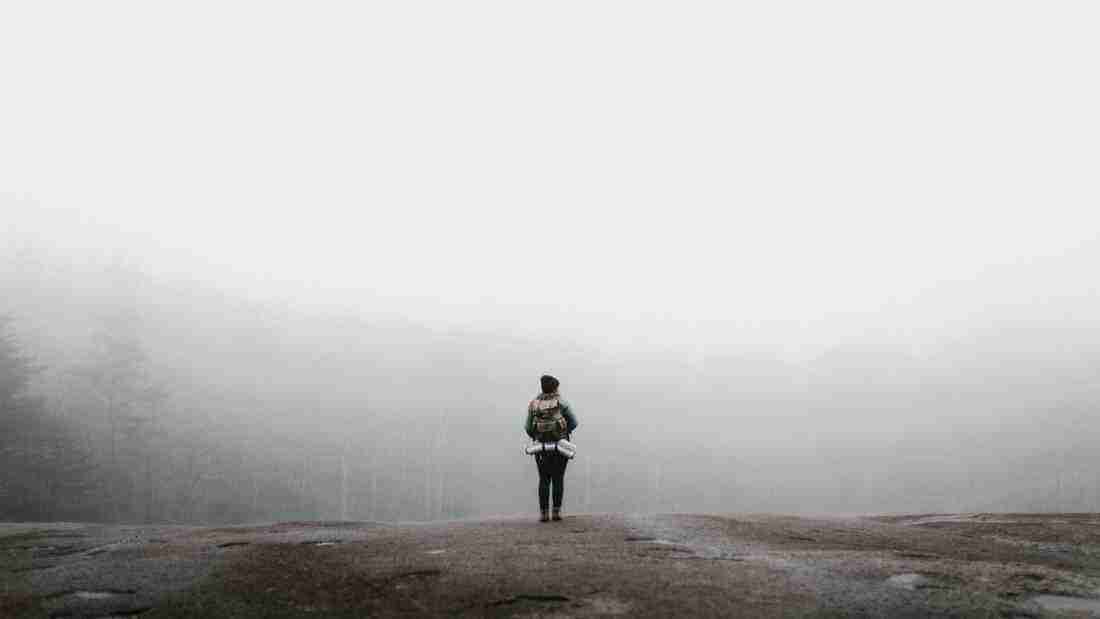 Woman in the clouds on top of a mountain