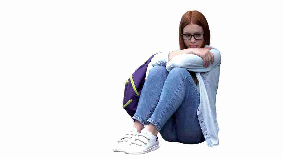 An insecure young woman sitting on the floor