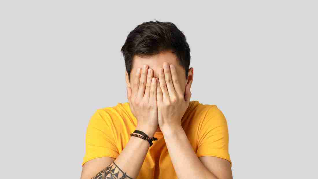 A woman covering her face with her hands