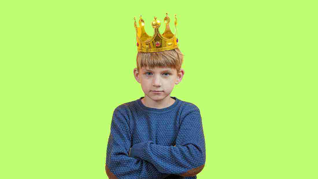 A little boy wearing a large crown denoting his privileged position in the family