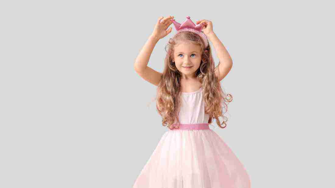 A little girl in a pink tutu and a pink crown