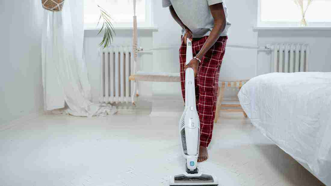 A man vacuuming a carpet