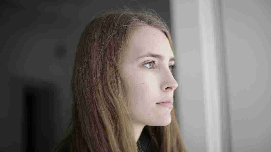 Young woman staring wistfully out of the window