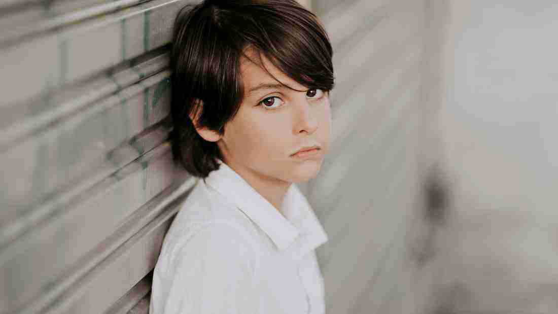 An unhappy boy glaring wistfully at the camera