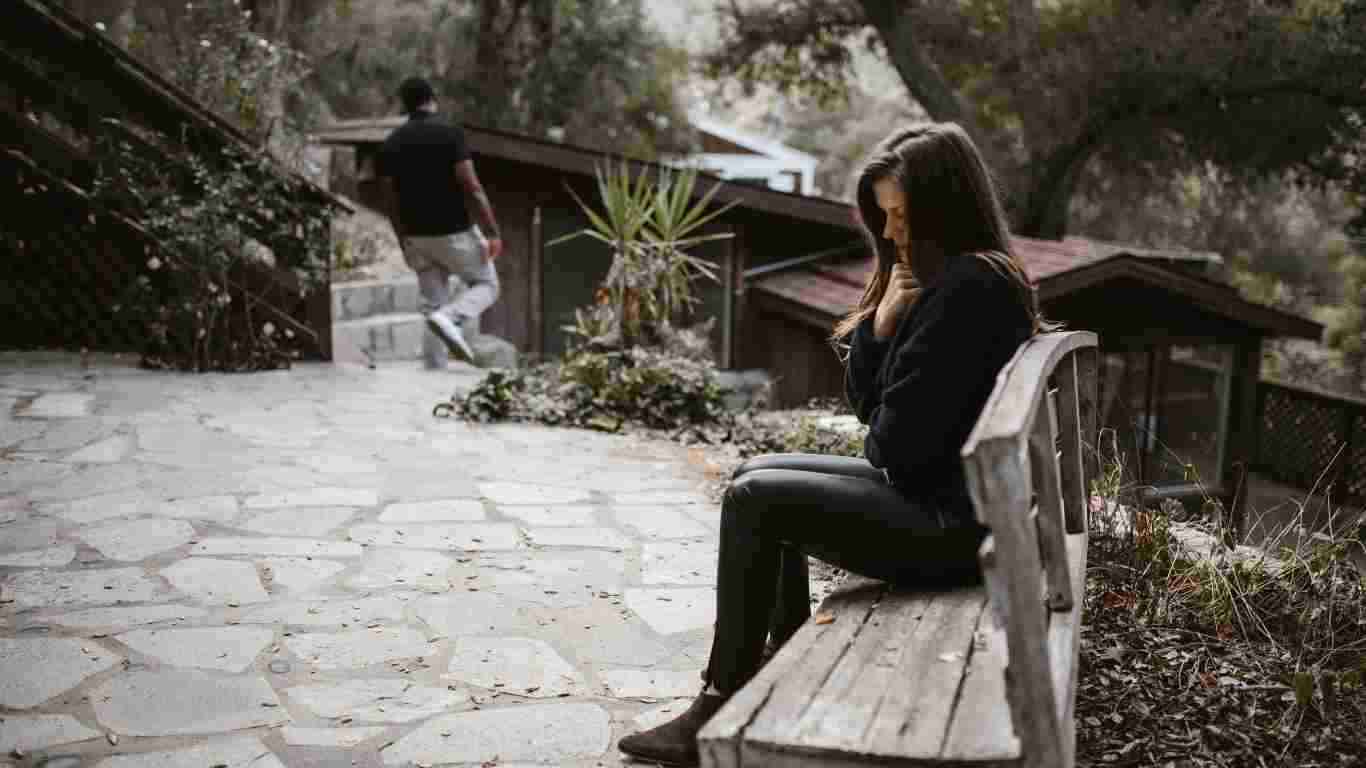 A traumatised woman sitting alone on a bench