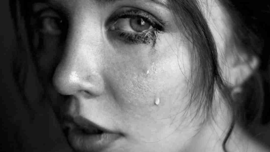 A young woman with tears streaming down her face