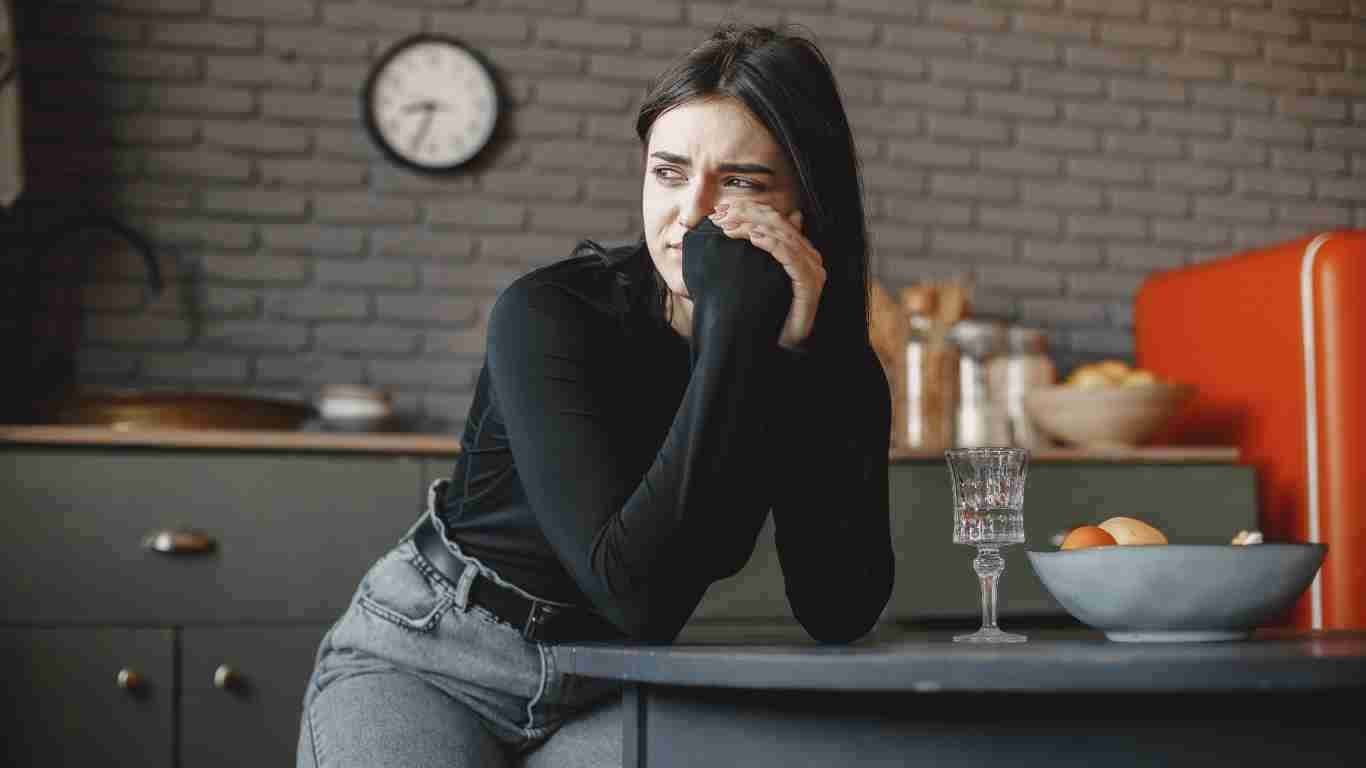 A very anxious young woman standing in a kitchen