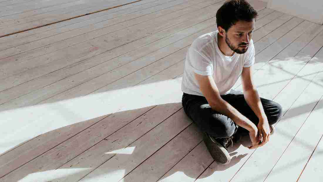A depressed young man sitting on the floor