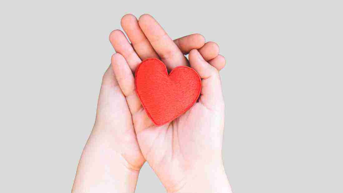A hand holding a heart, symbolizing kindness and empathy
