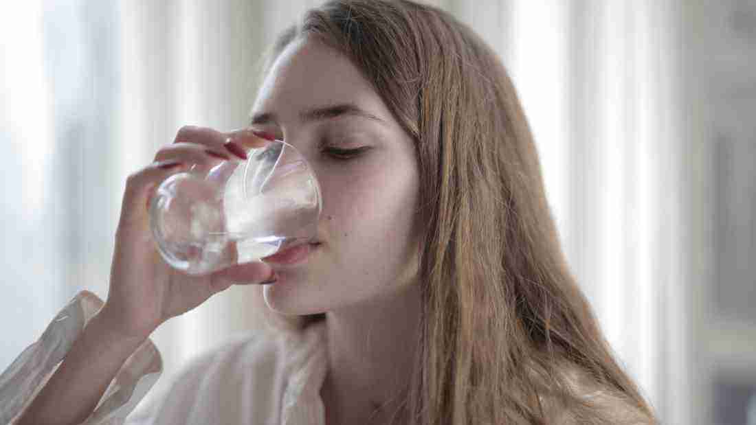 A woman drinking a glass of water