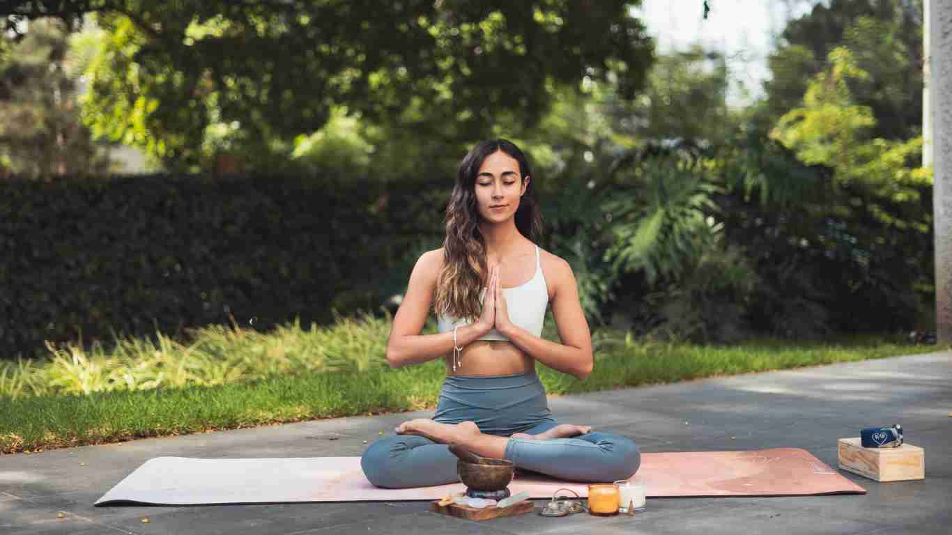 A woman meditating on her lawn