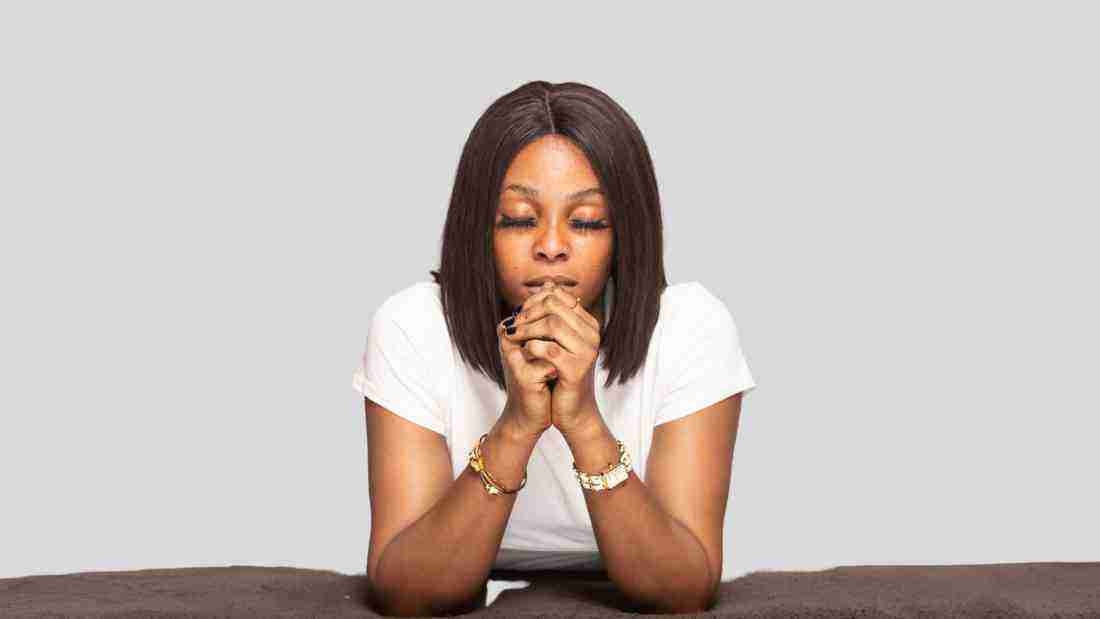 A woman kneeling in prayer