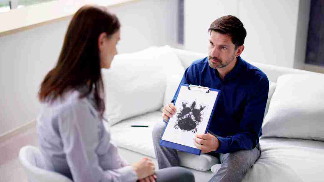 A therapist showing his client a Rorschach test