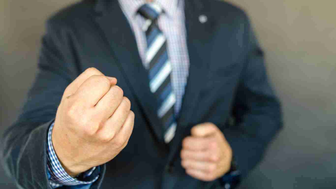 A man in a suit striking a very aggressive pose