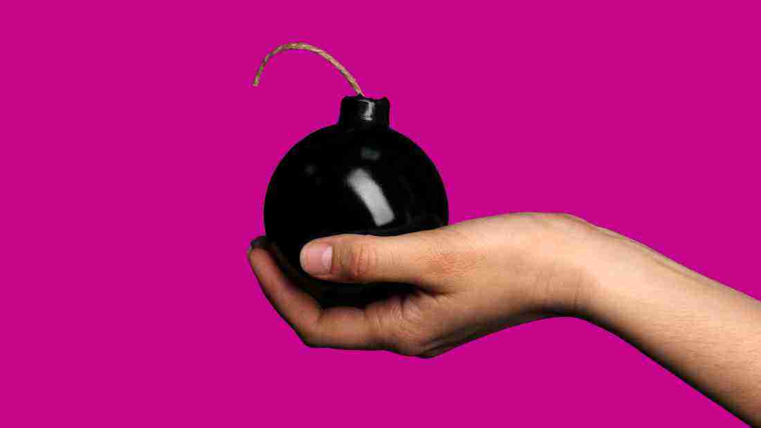 Self- sabotage - a woman holding a bomb that is about to explode