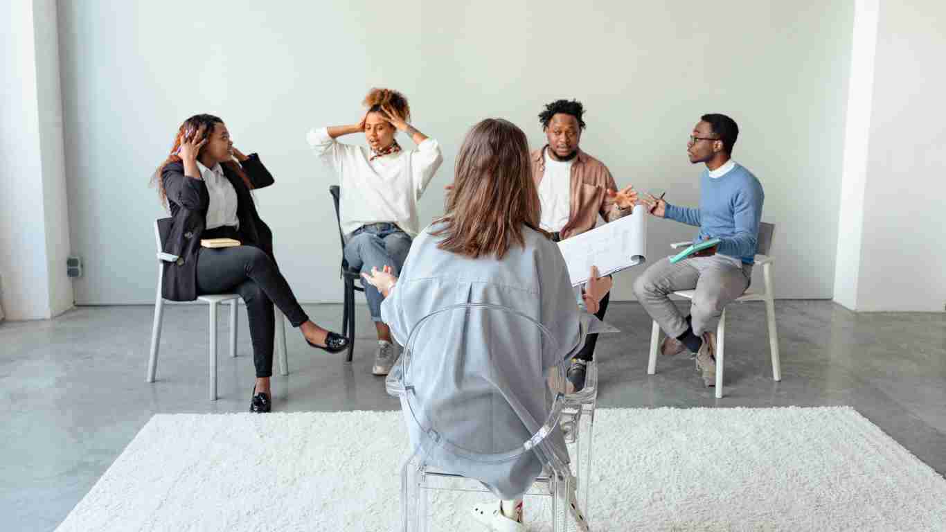 4 people with a therapist during a group therapy session