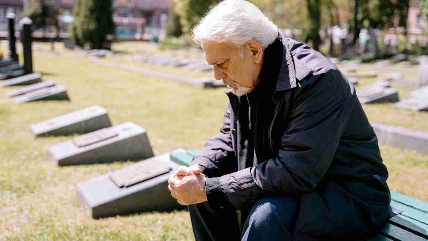 A man grieving in a graveyard