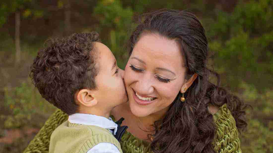 A young boy kissing his mother