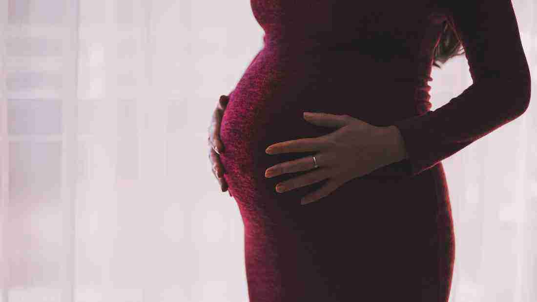 A pregnant woman cradling her baby bump