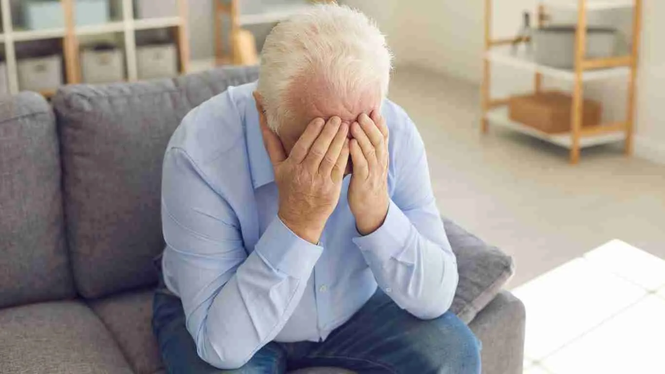A very sad old man sitting alone in his living room