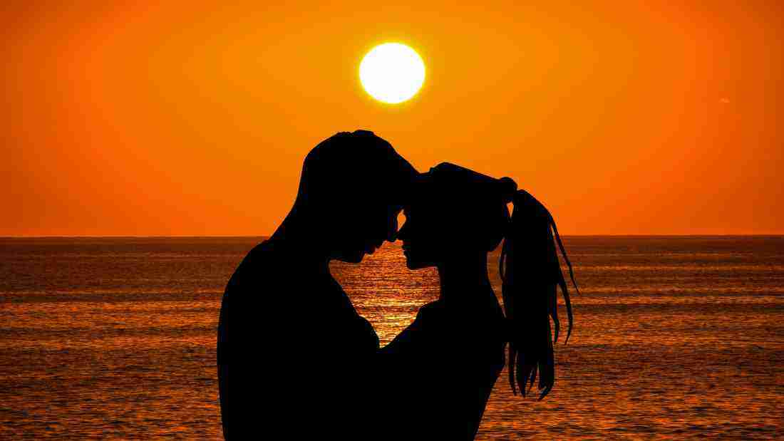 A couple embracing as the sun sets