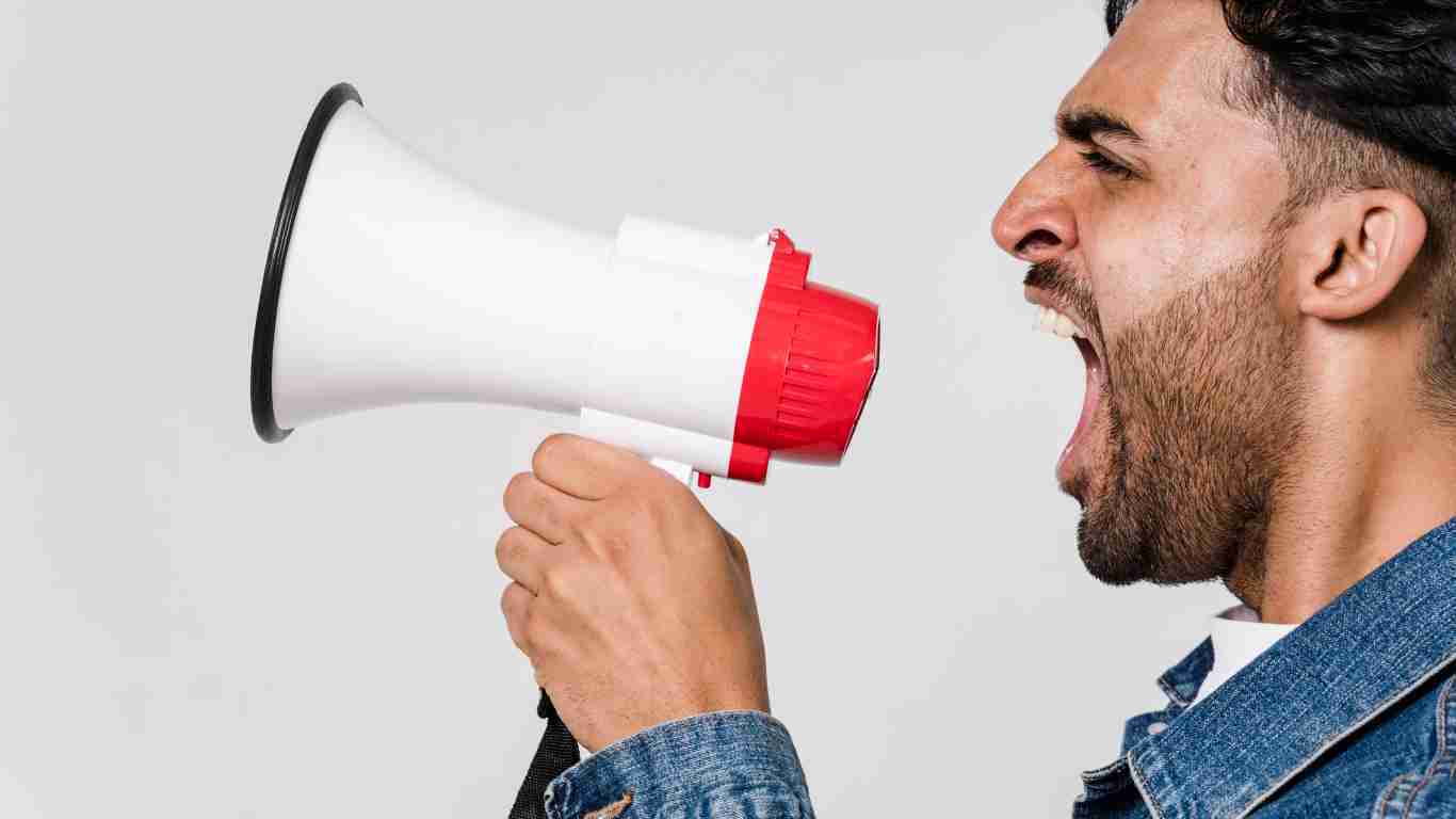An enraged man screaming into a megaphone