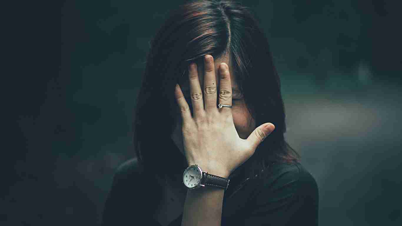 A woman covering her face in fear
